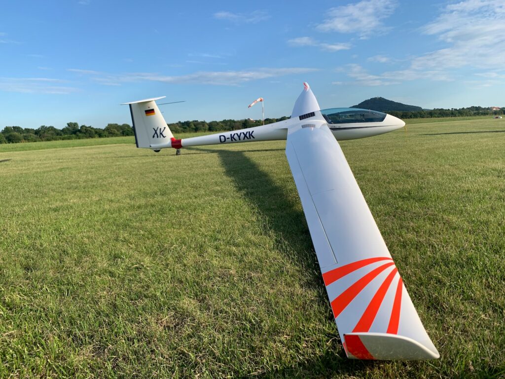 white and red airplane on green grass field during daytime