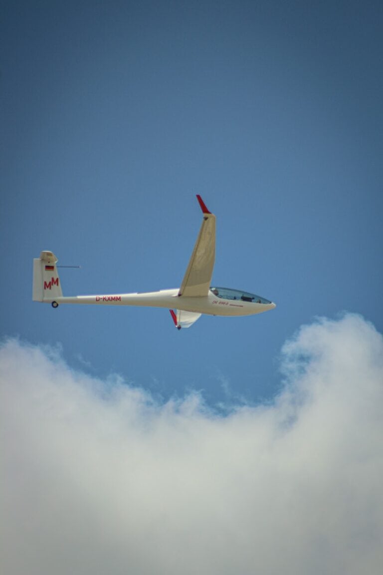 white and red airplane flying in the sky during daytime