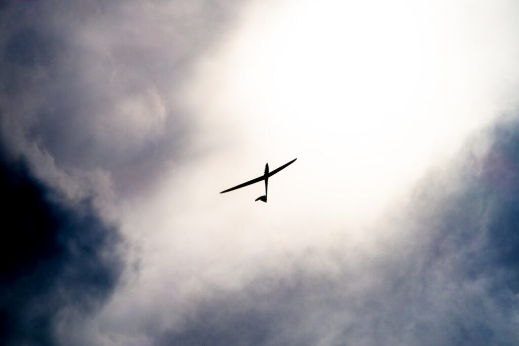 white toy plane under white sky