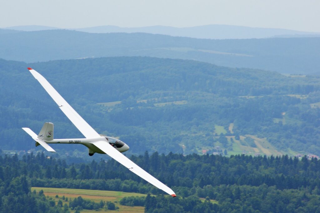 white plane flying mid-air during daytime