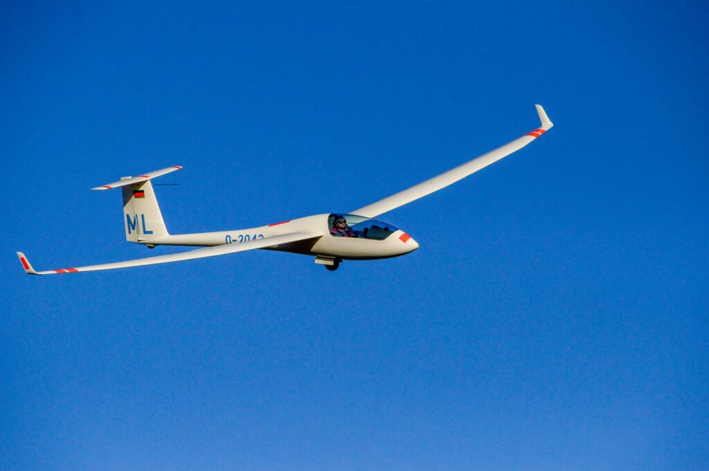 white and red airplane in mid air during daytime